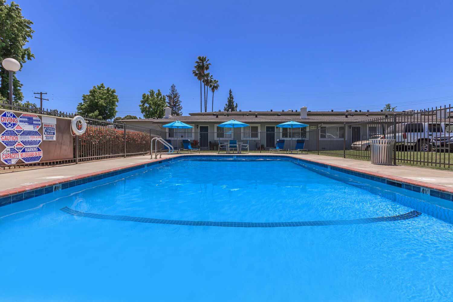 Pool with deck seating and umbrellas